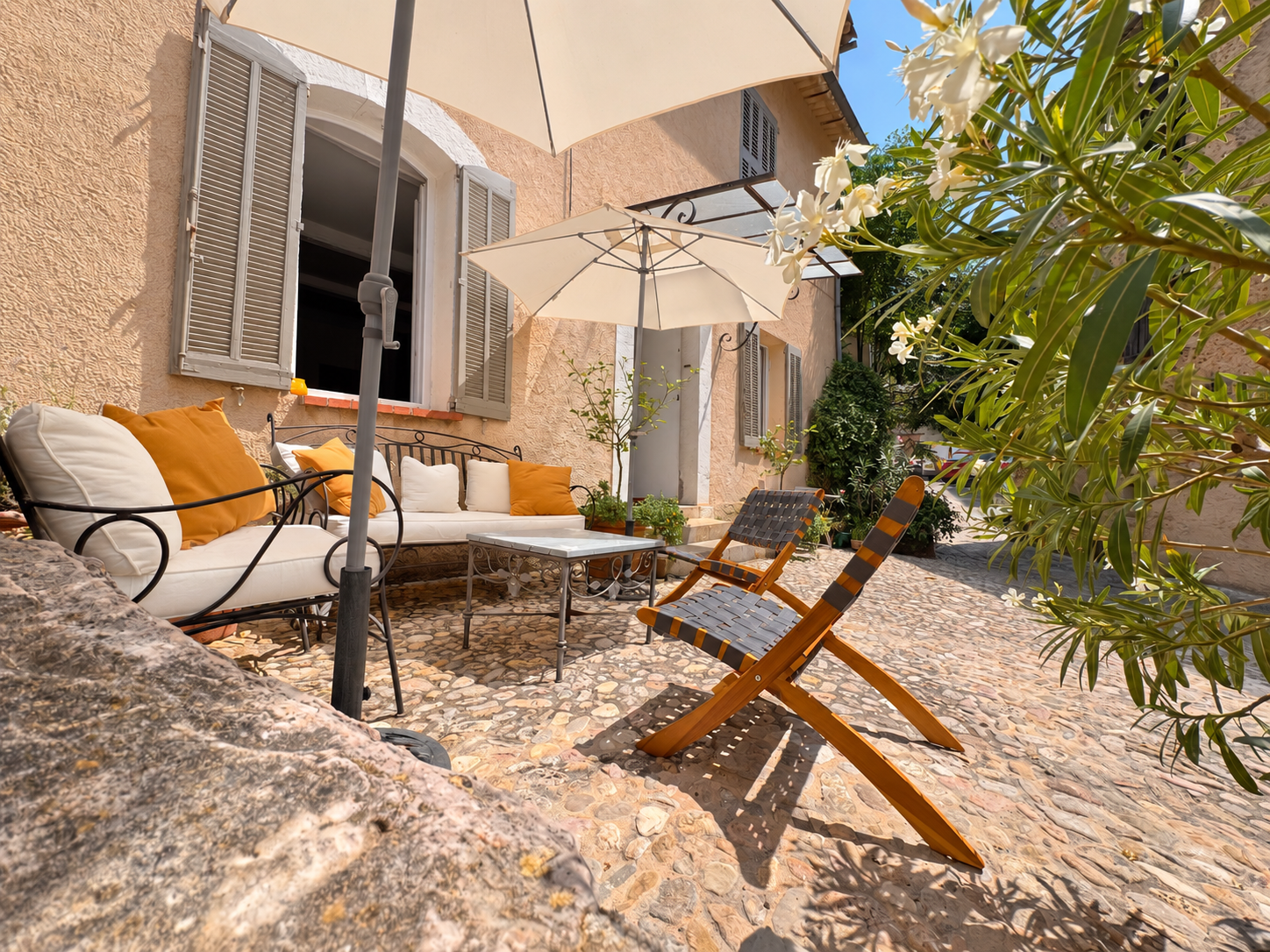 The lower terrace with cushioned seating, parasols and flowering greenery